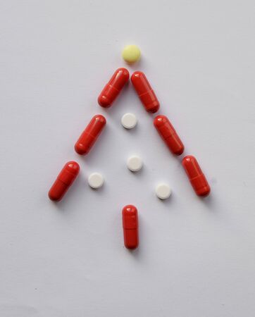 Christmas tree from Pharmacology assorted medicine pills, tablets and capsules. Different colors tablet on white background. Health care. Top view with Copy spaceの写真素材