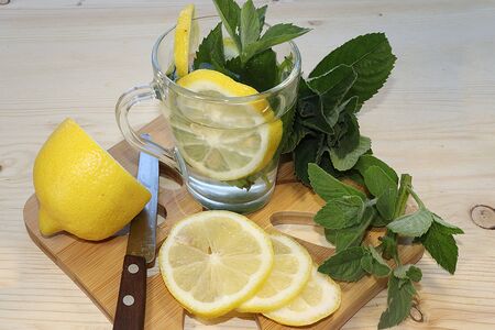 Herbal tea with mint, chamomile and lemon on a sunny table, top view. Summer drinks made from natural herbs are very useful and energize and have a good mood.の写真素材