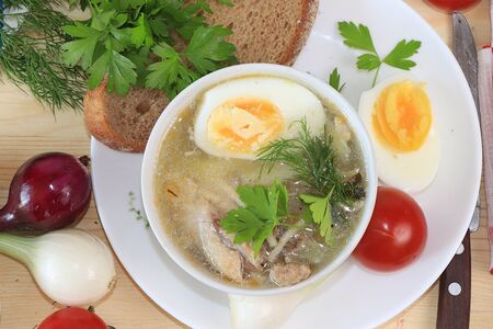 Traditional Russian soup with egg and bread on a wooden table. Delicious traditional natural food and cooking ingredients, healthy diet concept, top view, selective focus.の写真素材