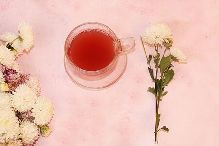 Autumn flowers and a cup of flower tea on the desktop, top view, flat lay, copy space. A break at work in the office in comfortable conditions, the cosiness of our home, good morningの写真素材