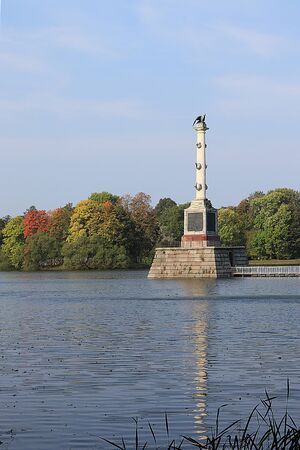 Russia, St. Petersburg, September 22, 2018, Catherine Park. In the photo the Chesme column in Tsarskoye Selo against the backdrop of an autumn park with red leaves and reflection in the lakeのeditorial素材