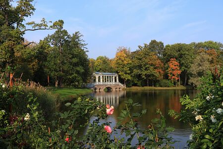 Russia, St. Petersburg, September 22, 2018, Catherine Park. Pictured Marble bridge in Tsarskoye Selo against the backdrop of an autumn park with red leaves and reflectionのeditorial素材