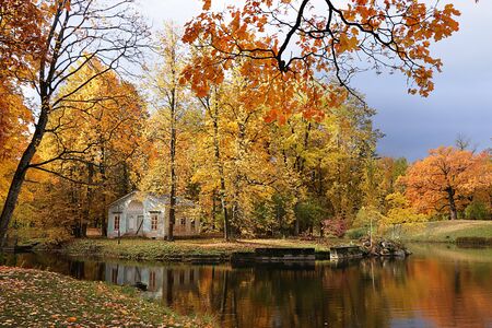 Russia, St. Petersburg, October 5, 2019, Alexander Park. In the photo - an autumn pond with fallen leaves and a children's house. The beauty of the October forest in Russian forestsのeditorial素材