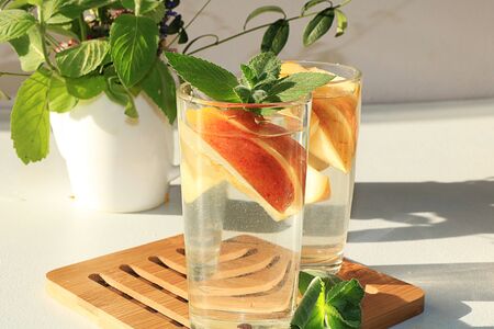 Apple cider, juice or fruit drink in a glass on a sunny table. The concept of diet and weight loss....
