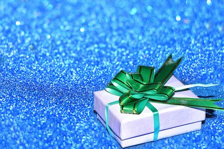 Christmas or New Year background with gift box on a background of blue bokeh lights, selective focus. Preparation for a happy congratulation, festive atmosphereの写真素材