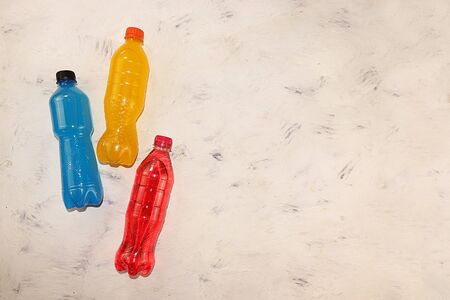 Isotonic energy drink in blue, yellow and red bottles on a concrete table, sports drinks to maintain body tone during workouts that support optimal hydration and vitalityの写真素材