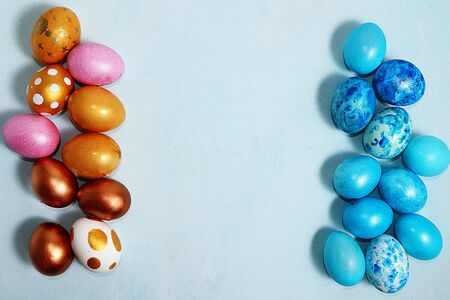 Decorated golden and blue easter eggs on a turquoise background. Minimal holiday concept. Happy easter background. Creative painting of eggs at home, the idea of simple drawings for coloring, a place for text, a postcard, aの写真素材