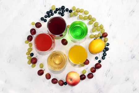 Fruit cider, juices or fruit drinks in glasses and ingredients on a sunny table. The concept of a detox diet and weight loss, healthy and natural nutrition, bar. Healthy breakfast, place for text, lifestyle.の写真素材