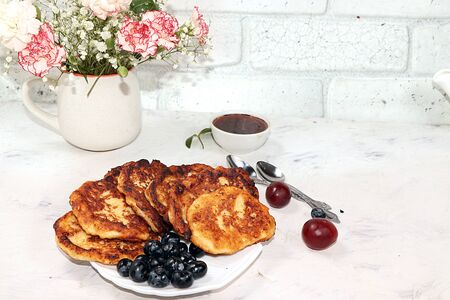 Pancakes with berries, blueberries and grapes, on a sunny sunny background. The concept of healthy...