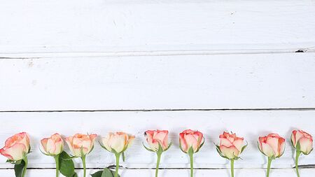 Arrangement of flowers on a wooden isolated background, place for text, flat lay. Creative modern bouquet, minimal holiday and spring concept. Greeting card for Women's Day or Valentine's Day, happy birthday, wedding,の写真素材