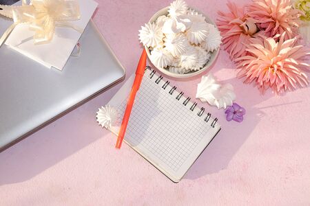 Stylish modern home office, comfortable workplace, computer, flowers, greeting card on a light table, minimal home office conceptの写真素材