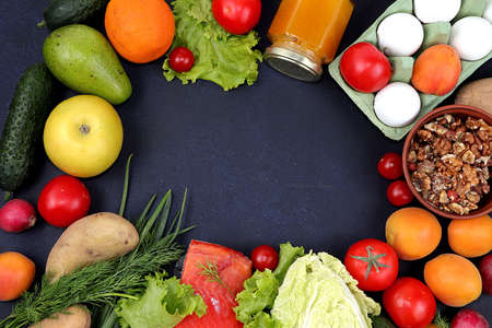 Vegetables, fruits and red fish on a dark background. The concept of healthy and natural food for...