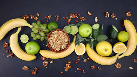 Vegetables, fruits and granola on a dark background. The concept of healthy and natural food for weight loss, lifestyle, detox diet, the purpose of which is to eliminate carbohydrates and cleanse the body, a place for textの写真素材