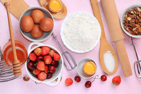 The recipe for making strawberry cherry pie, cooking. Eggs, flour, Sazar, strawberries and honey, top view, flat lay. Background of bakery products,の写真素材