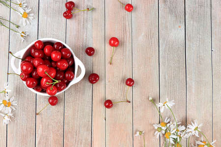 Fresh berries of cherries in a basket on a light table, top view, sweet cherry on a wooden light background, selective focus. Natural food concept, healthy breakfast,の写真素材