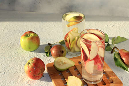 Apple and pear cider, juice or fruit drink in a glass on a sunny table. The concept of diet and...