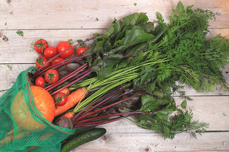 Healthy natural products in eco bag, healthy lifestyle concept.Fresh vegetables, carrots, beets, cucumbers, tomatoes and pumpkins, diet food ingredients, flat lay, harvestingの写真素材