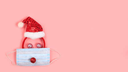 Christmas composition with decorations and medical mask, greeting card, minimal holiday concept, modern new year background, banner for the screen, space for text,の写真素材