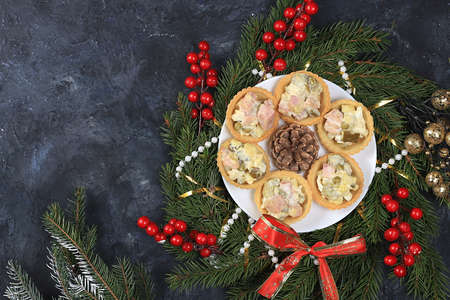 Christmas new year dishes, traditional festive olivier salad with fir branches and cones and decorations on a light table, dish design idea, selective focus,の写真素材