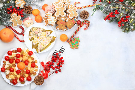 Christmas new year food, traditional festive salad olivier and cheese with tomatoes, grapes and gingerbread with fir branches and cones and decorations, dish design idea,の写真素材