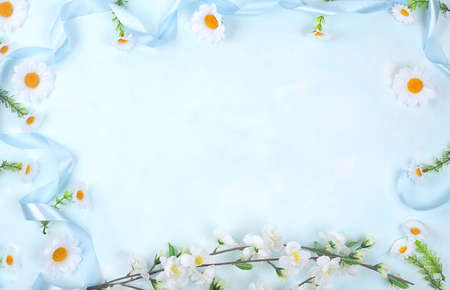 Abstract spring card, delicate blue background with daisies and a blossoming branch with place for...