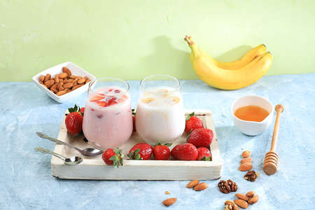 Strawberry and banana smoothies with berries and banana on a bright table. Useful breakfast made with ingredients. Healthy and natural food concept, lifestyle, selective focus,の写真素材