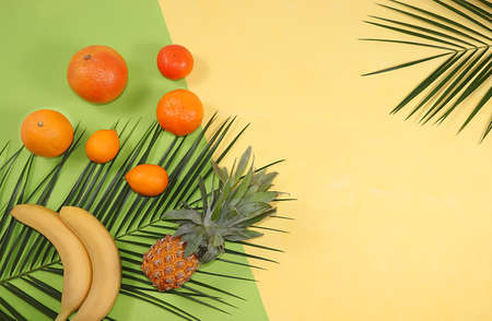 Tropical fruits, pineapple, grapefruit, orange, lemon on palm leaves, shop banner. Detox diet, minimal summer vacation concept. Space for text, flat lay.の写真素材