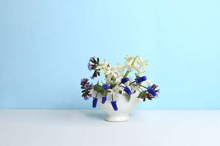 Muscari and hyacinth flowers in a vase.Abstract floral arrangement, background, minimal holiday concept with flowers, spring banner, home decor.Mothers day card, happy birthday, wedding, place for text, selective focusの写真素材