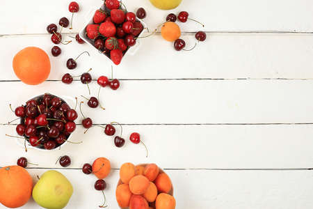 Summer berries and fruits on wooden background, harvesting in the village, healthy natural food concept, breakfast with ingredients, top view, shop advertisement, business card for cafe, selective focusの写真素材