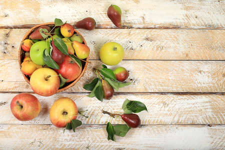 Autumn composition of apples and pears on a sunny wooden table, thanksgiving background, harvesting, healthy natural food concept, detox diet and body cleansing, banner for screen, cafe, restaurant, selective focusの写真素材