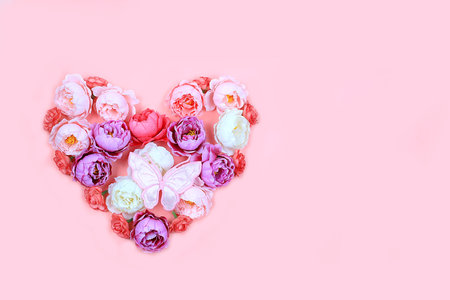 Floral heart with butterflies on pink background.Concept for Valentine's Day or Women's Day, Mother's Day, banner, congratulations to your beloved on the holiday, birthday, minimal modern designの写真素材