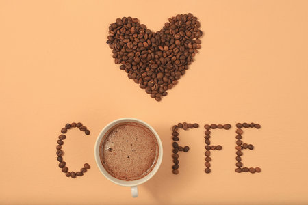 Heart shaped roasted coffee beans and text i love coffee on beige background,top view,flat lay,minimal creative concept,advertising for modern coffee shop,cafe,bar,selective focusの写真素材