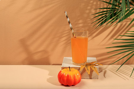 Pumpkin drink, juice on a light background .Modern still life on a pastel background with long hard shadows, minimal detox concept, traditional thanksgiving drink rich in antioxidants, used for weight loss and healing, selective focusの写真素材
