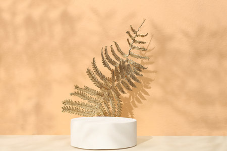 Premium podium with golden autumn leaves and product display stand. Creative autumn composition, minimal autumn concept, screen banner with place for text. Happy Thanksgiving and greeting card, selective focusの写真素材