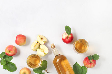 Apple cider, juice or fruit drink and ingredients on a sunny table. The concept of diet and weight loss. Apples help cleanse the body and reduce weight. Healthy food, body detoxification, selective focusの写真素材