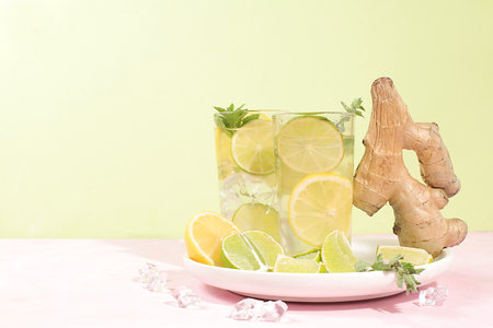 Detox drink with lemon, mint, lime, ginger and orange on a light table, cocktail improves metabolism...