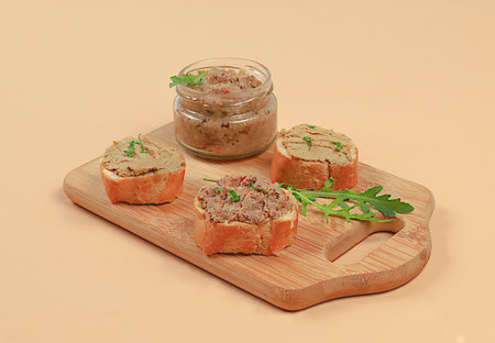 Chicken pate with homemade whole grain bread and herbs on a light table, the concept of a healthy...