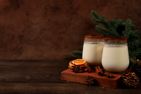 Eggnog with cinnamon and nutmeg for Christmas and winter holidays. Warming egg drink during the cold season, holiday composition, selective focusの写真素材