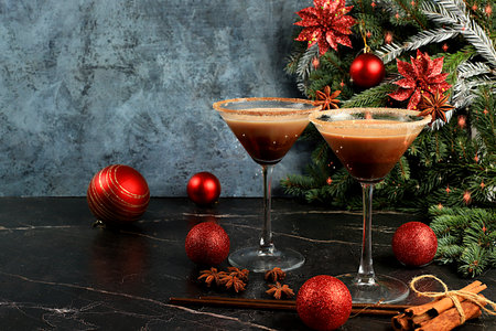 Christmas martini with cinnamon, nutmeg and dark chocolate on a dark background with fir branches, concept for Christmas and winter holidays. Warming milk drink during the cold season, selective focusの写真素材