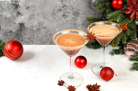 Christmas martini with cinnamon, nutmeg and dark chocolate on a dark background with fir branches, concept for Christmas and winter holidays. Warming milk drink during the cold season, selective focusの写真素材