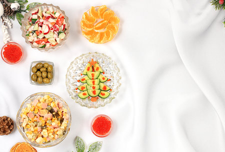 Christmas New Year dishes, traditional Olivier salad, vegetable salad of cucumbers, tomatoes and radishes and a variety of vegetable snacks, holiday serving concept, selective focusの写真素材