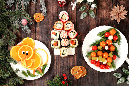 Christmas tree made of fresh sushi rolls and vegetables, Christmas New Year food, banner for advertising a store, bar, menu for a cafe, ideas for preparing and serving holiday dishes, top view, selective focusの写真素材