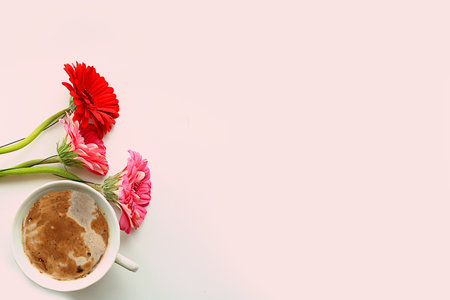 Floral arrangement with gerbera flowers and a cup of coffee. Concept for Valentine's Day or Women's...