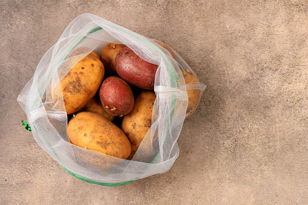 Various varieties of potatoes in fabric packaging. Healthy natural products in an eco bag to boost immunity, healthy lifestyle concept, zero waste. Banner for the store. No plastic. Selective focusの写真素材