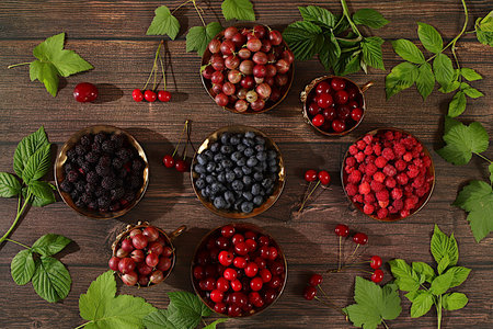 Summer fresh berries, cherries, blackberries, gooseberries, blueberries and raspberries on a wooden...