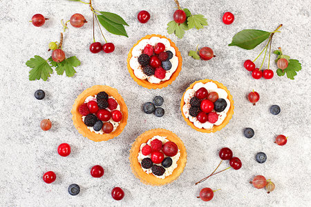 Cupcakes with soft curd cream, Delicious tartlets with fresh berries raspberries, cherries,...