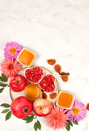Autumn banner with honey, apples, pomegranates, flowers, dried fruits on light background, composition for Jewish holiday Rosh Hashanah, autumn greeting and thanksgiving concept, selective focus,の写真素材