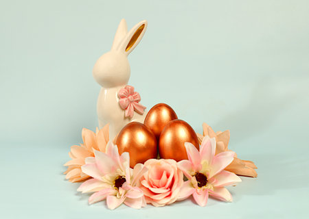 Abstract easter composition with painted golden eggs, bunny and spring flowers. Holiday design...