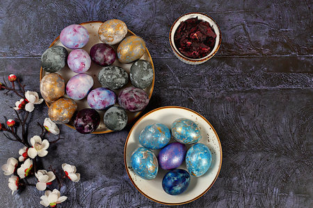 Easter celebration concept, Easter marble eggs dyed with natural hibiscus tea with sakura branch on...