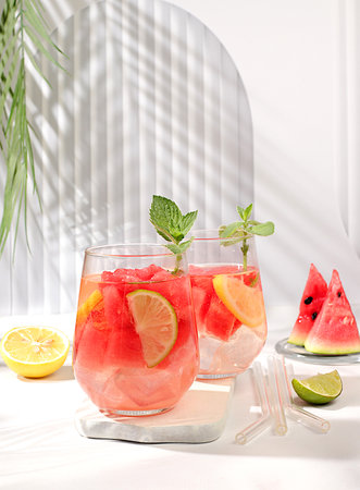 Detox diet and summer party concept. Cold homemade lemonade or cocktail with mint, watermelon and fruits on a sunny table, Refreshing summer drink recipe, restaurant menu, selective approach.の写真素材